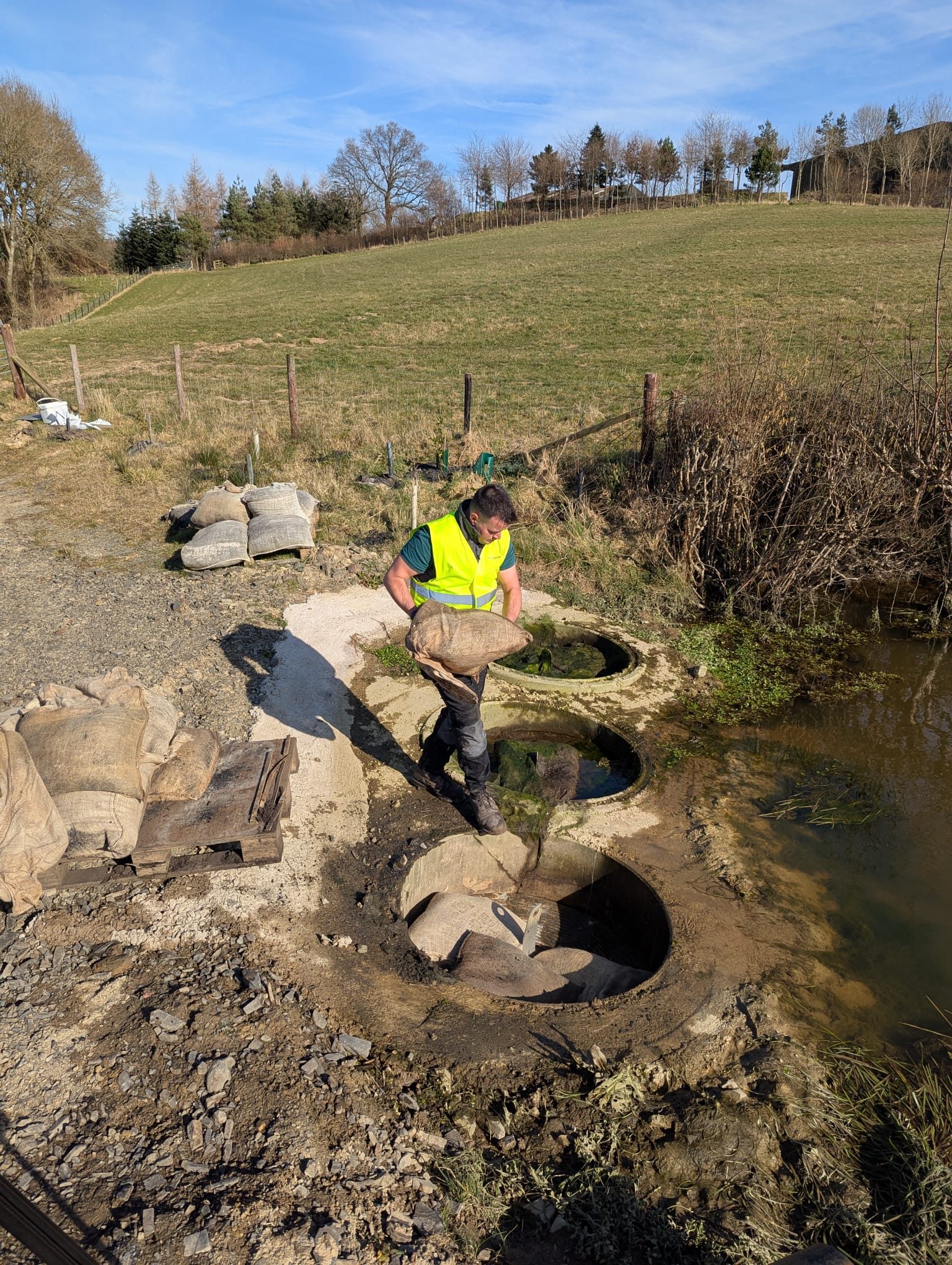 Biochar water filtration bags going into the filter rings at Carbon Hill